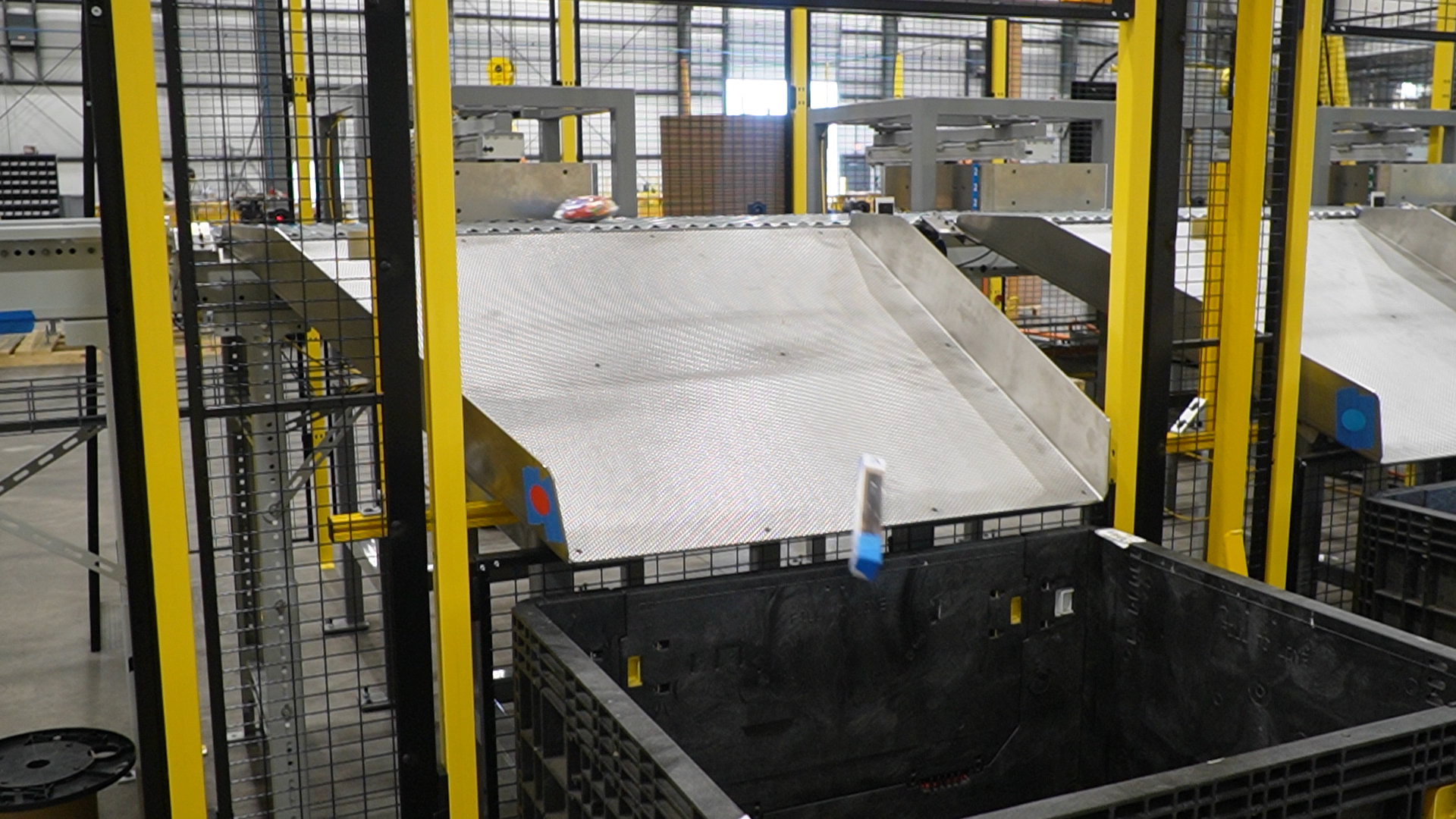 Package being automatically diverted from the sortation conveyor into a destination Gaylord