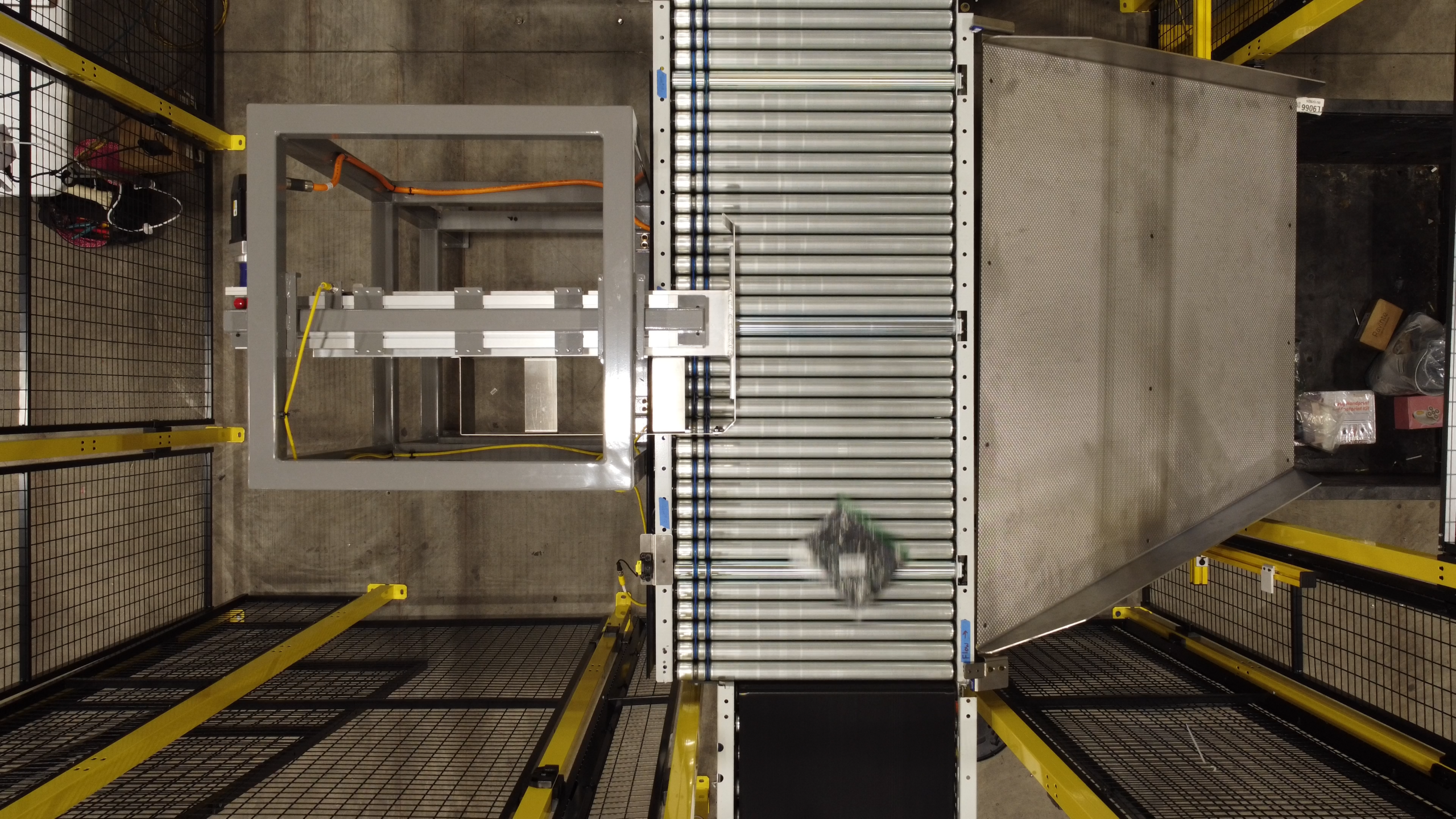 Overhead view of an automated package sortation conveyor diverting a package into a destination container
