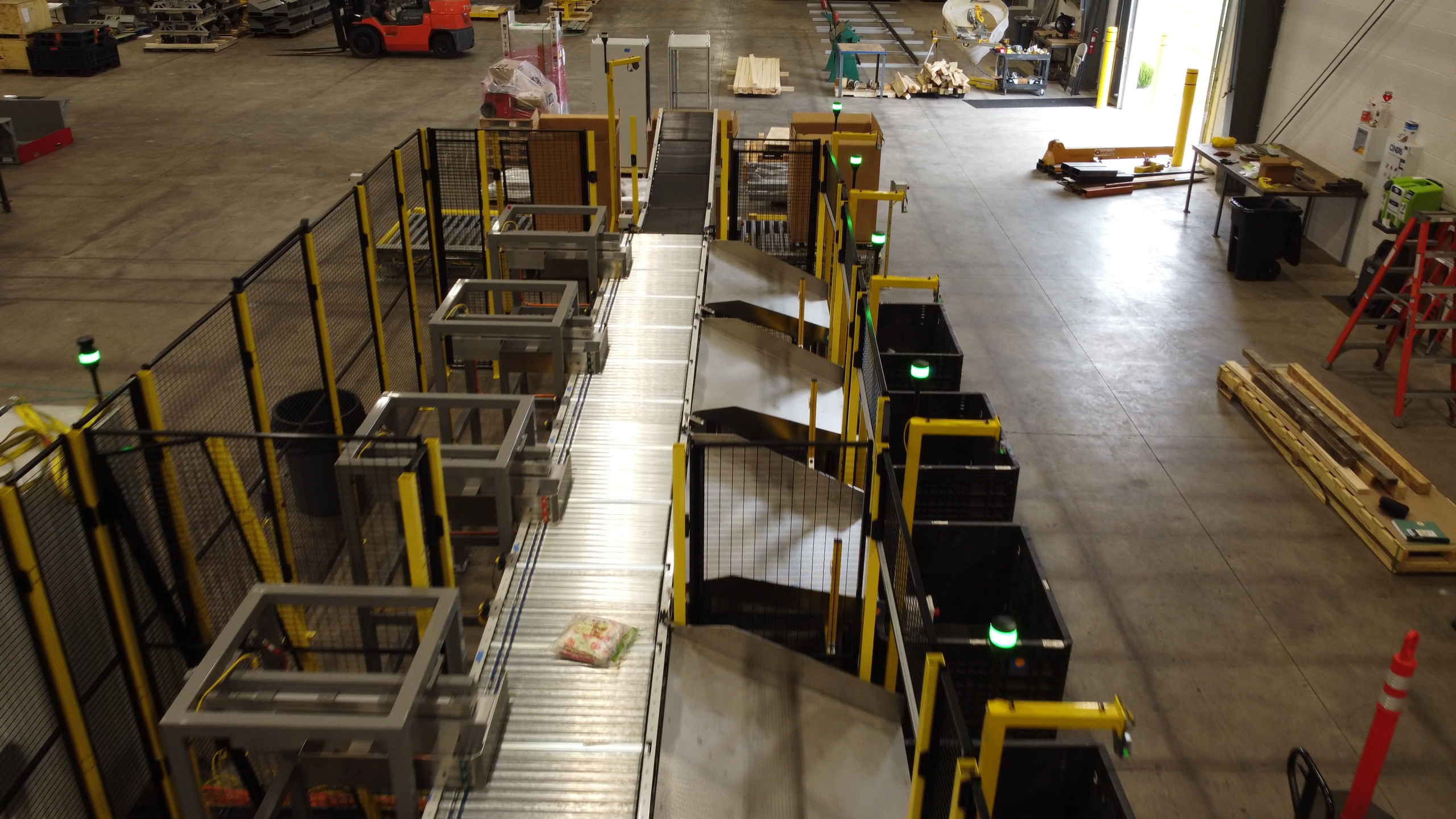Overhead view of an automated package sortation system routing packages into multiple destination containers